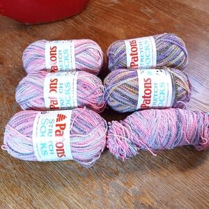 6 Skeins of Patons light weight stretchy sock yarn. 4 pink/grey 2 purple/yellow